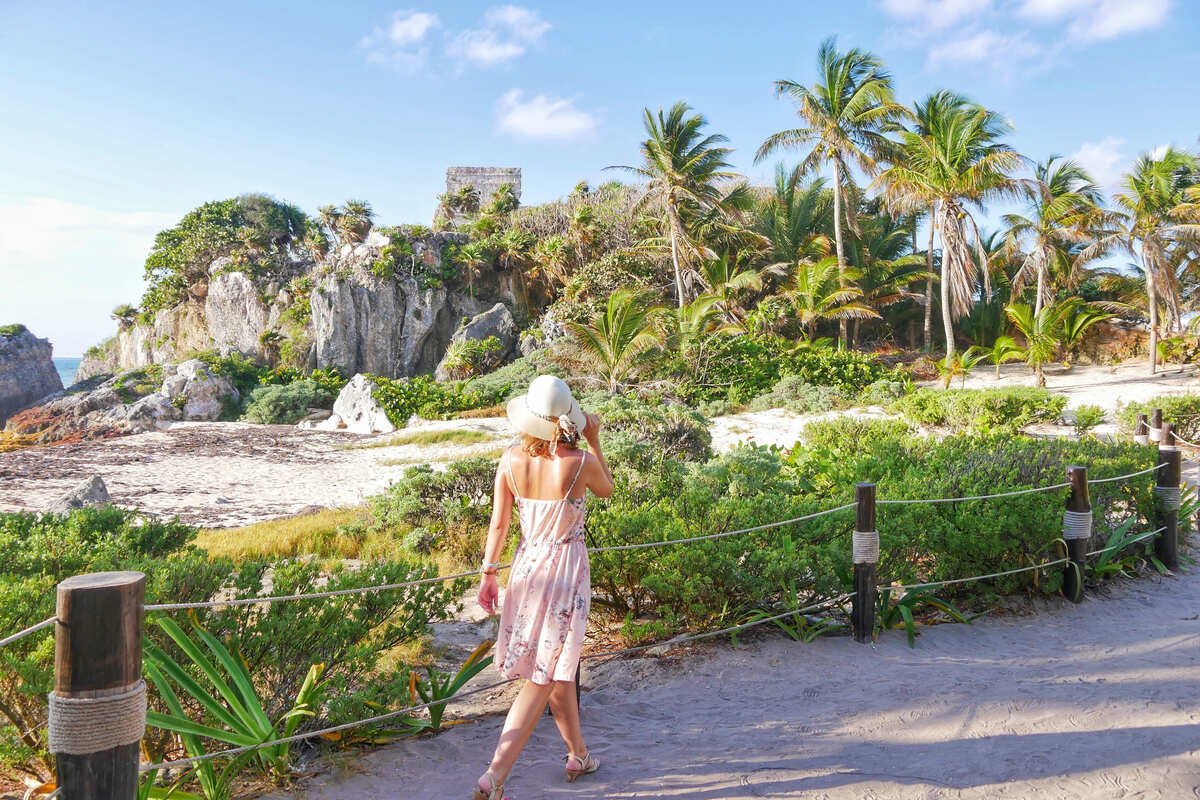 Young Woman Walking The Historical Archaeological Zone In Tulum, Quintana Roo, Mexico