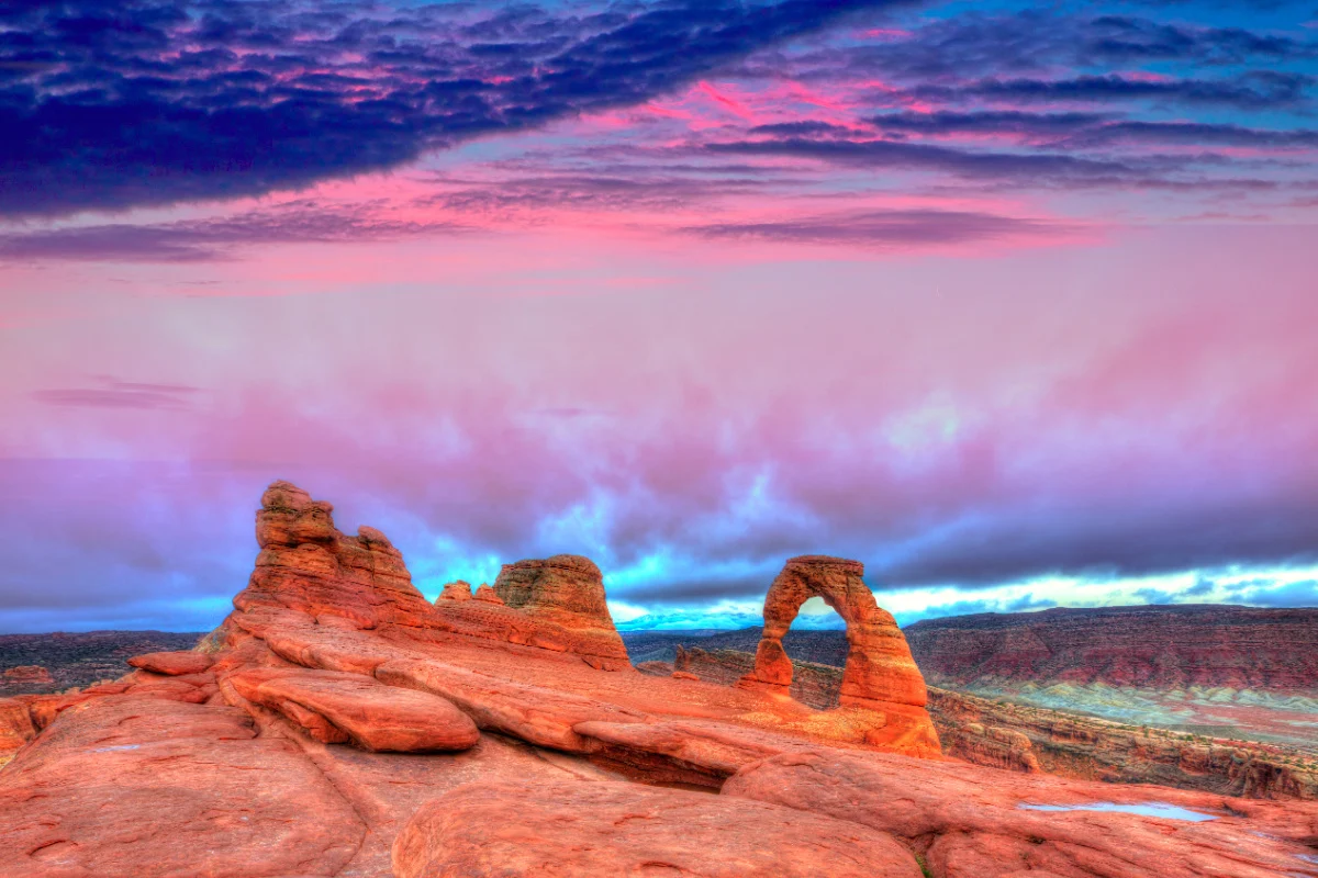 Red rock formations under cotton candy skies in Arches National Park